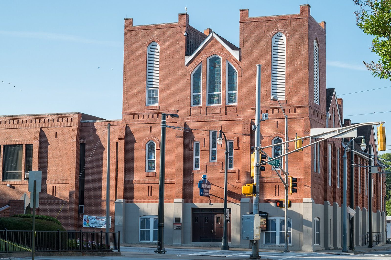 The red brick facade of Historic Ebenezer Baptist Church on Auburn Avenue in Atlanta, with twin crenellated towers and arched stained glass windows