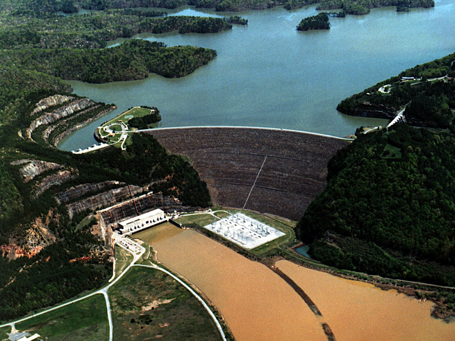 Aerial view of Carters Dam on the Coosawattee River in Murray County, Georgia, with the blue reservoir above the earth dam and the muddy tailrace below