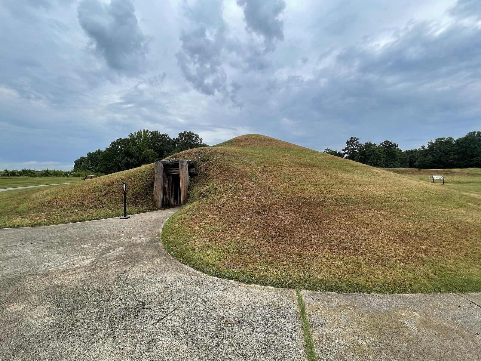 The grassed mound of the reconstructed Earth Lodge at Ocmulgee Mounds National Historical Park in Macon, Georgia, with its timber entrance passage